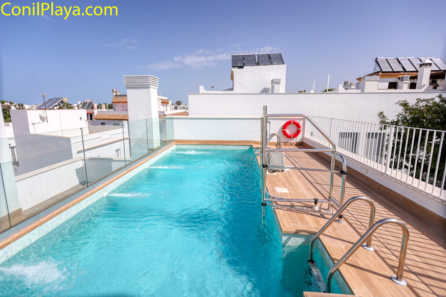 Piscina privada en azotea rodeada de barandilla y edificios cercanos
