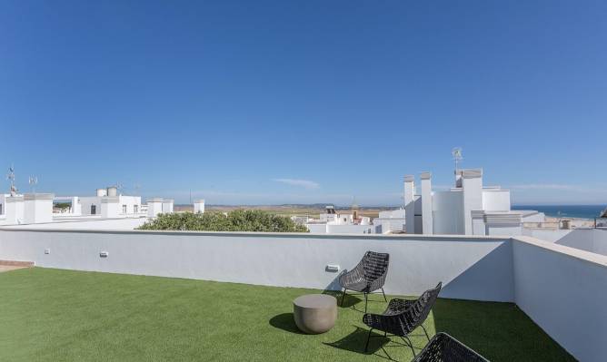 Terraza amplia con césped artificial y mobiliario moderno vista desde la esquina
