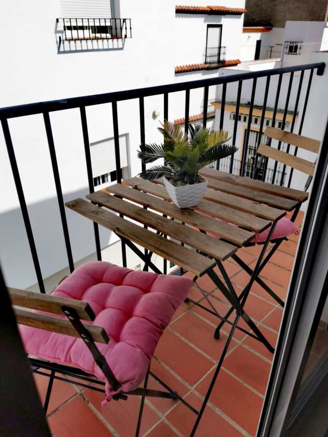 terraza del apartamento con mesa y 2 sillas