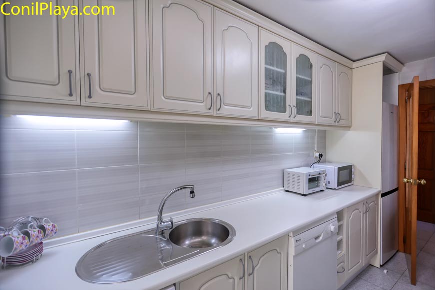 Fregadero y zona de preparación en cocina clásica Zona de fregadero y preparación de alimentos con microondas y muebles de estilo clásico.