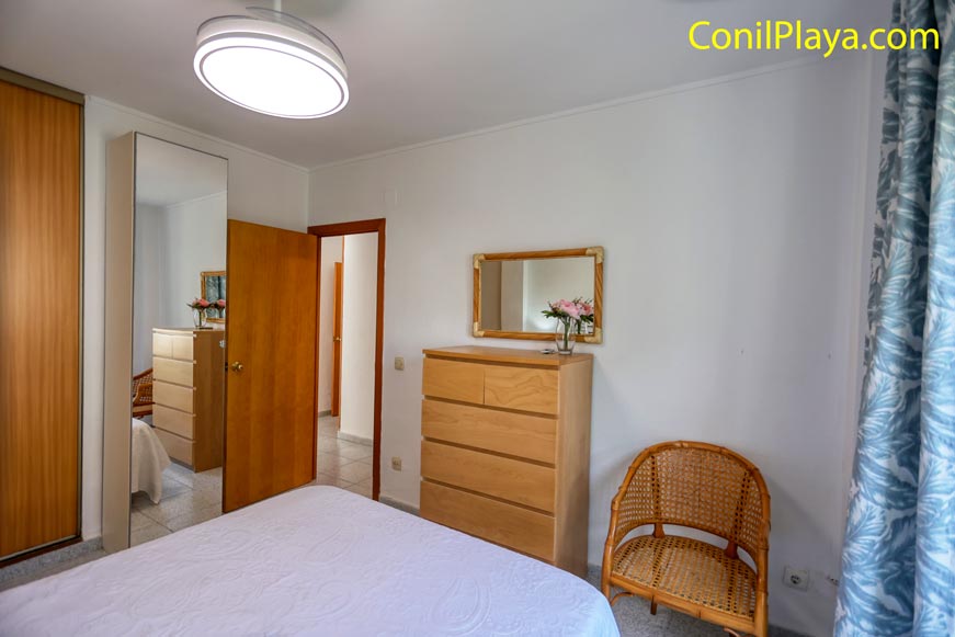 Sinfonier con espejo y ventilador de techo en el dormitorio principal Sinfonier clásico con práctico espejo en el dormitorio principal bien ventilado.