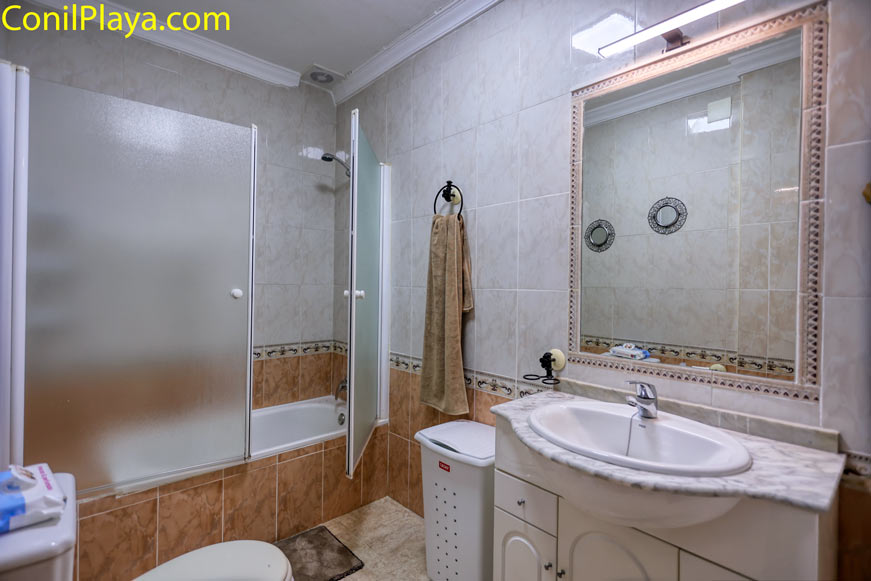 Cuarto de baño con bañera, mampara y mueble de lavabo blanco