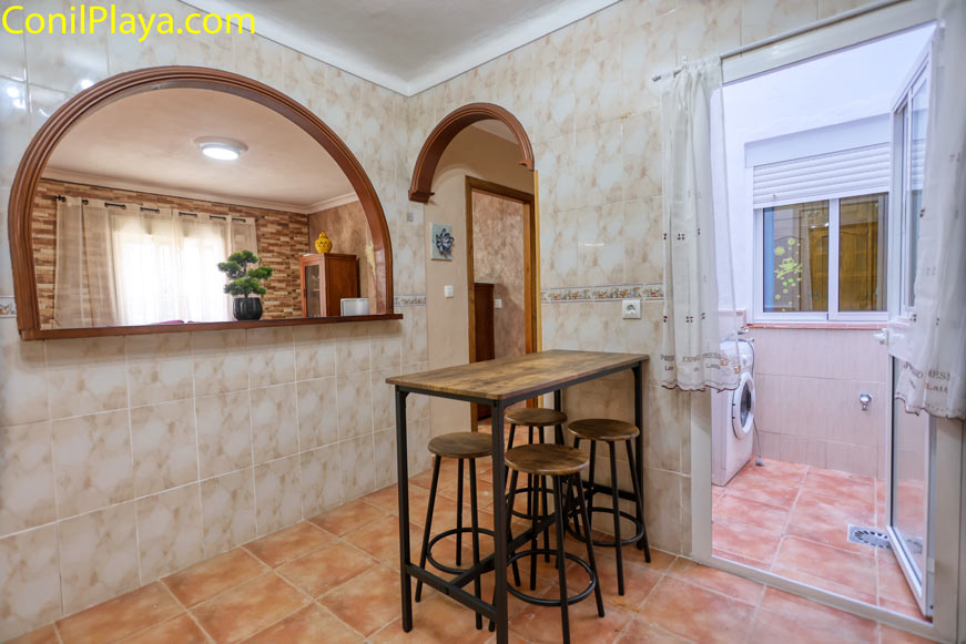 Barra de madera alta con taburetes en zona de cocina