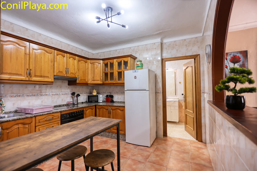 Cocina completa con muebles de madera rústica y electrodomésticos