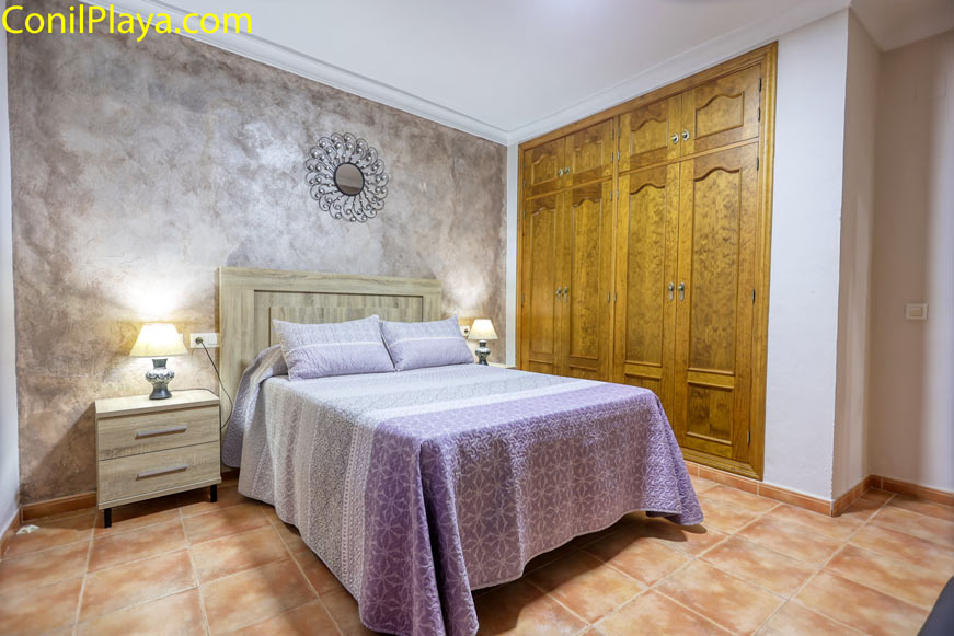 Dormitorio con cama de matrimonio y gran armario empotrado de madera