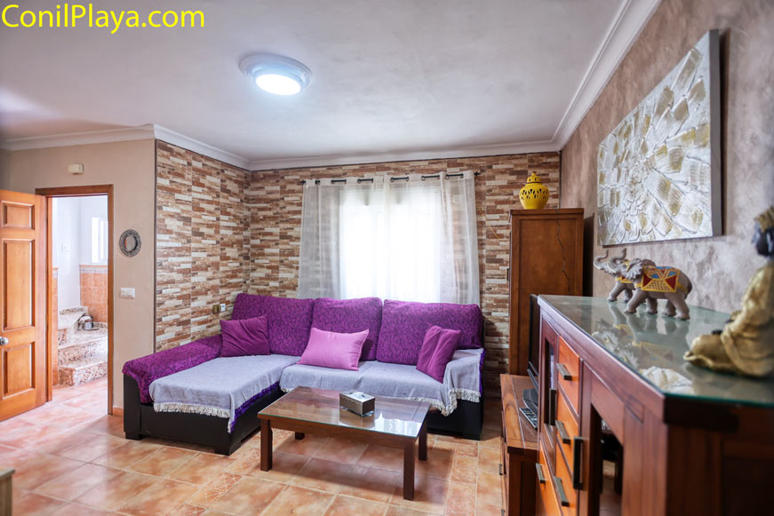 Salón con sofá chaiselongue púrpura y mesa de centro de madera