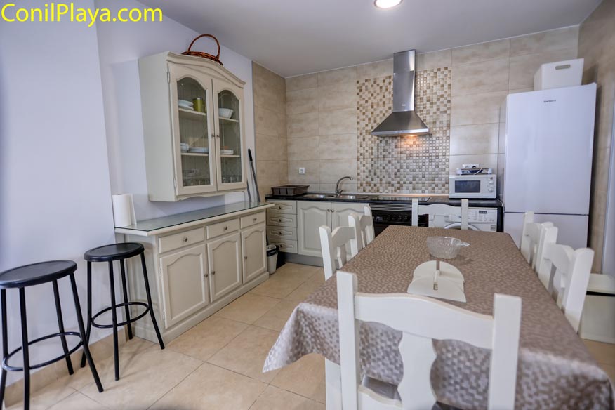 Detalle del mueble alacena y mesa de comedor preparada para seis personas.