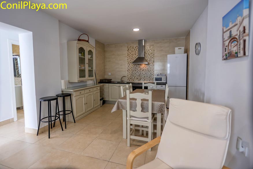 Vista amplia de la cocina y comedor con sillón relax en primer plano.