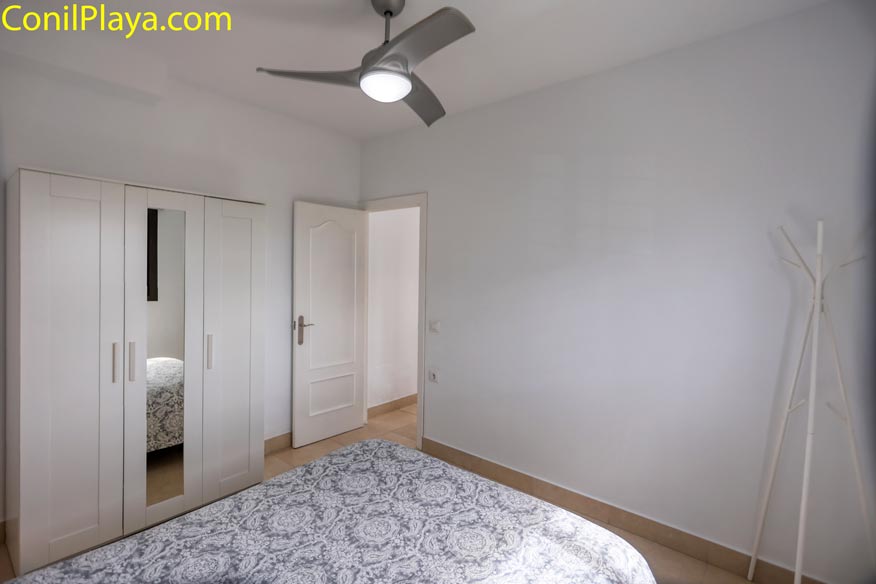 Vista del dormitorio desde la cama mostrando el ventilador de techo y el armario.