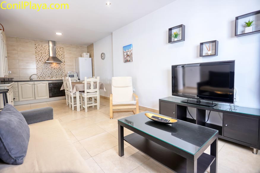 Vista desde el sofá hacia el comedor y la cocina al fondo, espacio diáfano.