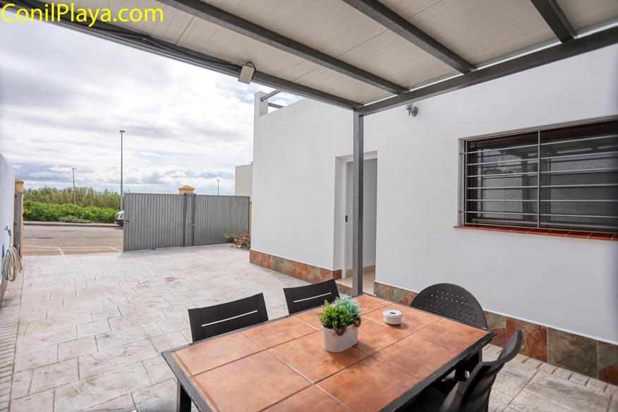Vista desde el porche hacia la puerta de acceso y el patio exterior.