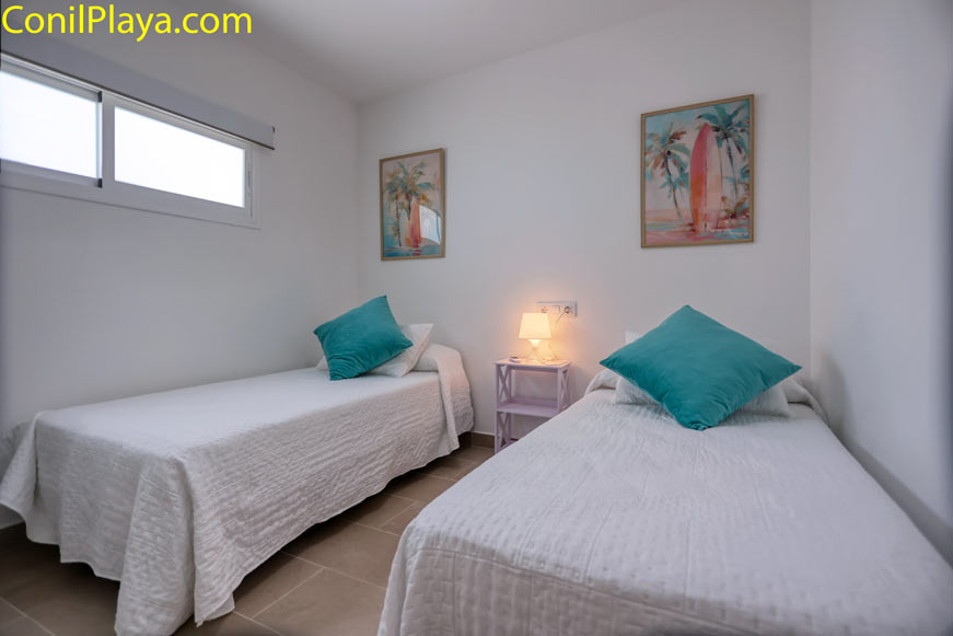 Dormitorio secundario con dos camas individuales y decoración estilo playa