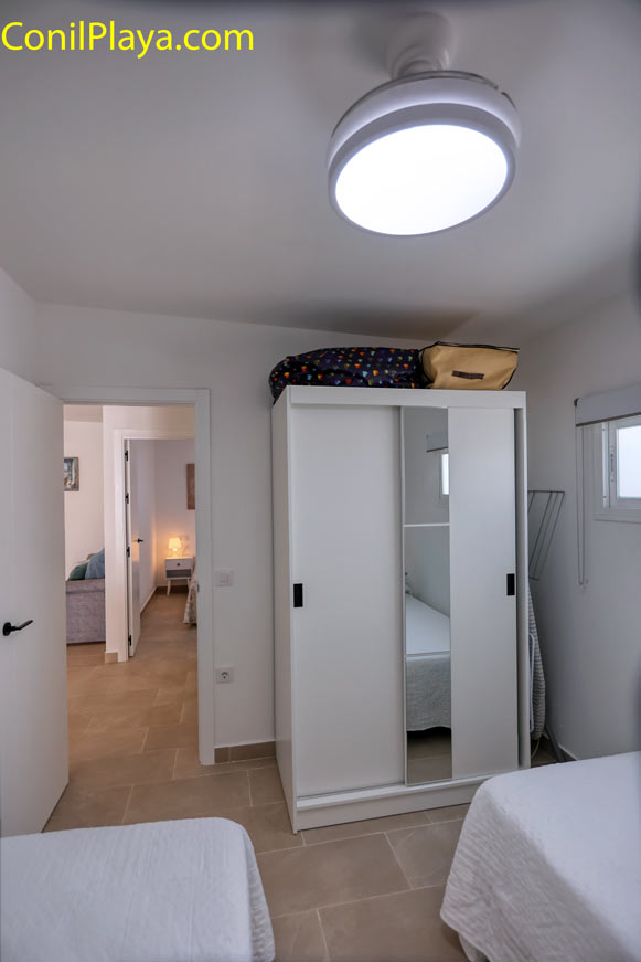 Vista del dormitorio doble con armario de puertas correderas y espejo