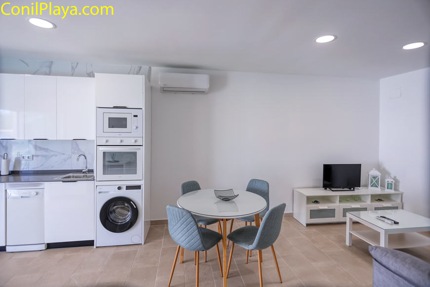 Mesa de comedor redonda junto a zona de televisión y climatización