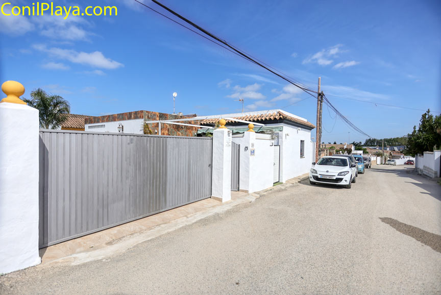 Coches estacionados junto a entrada de casa y portón en calle tranquila