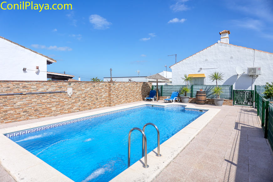 Piscina vallada con tumbonas y macetas decorativas