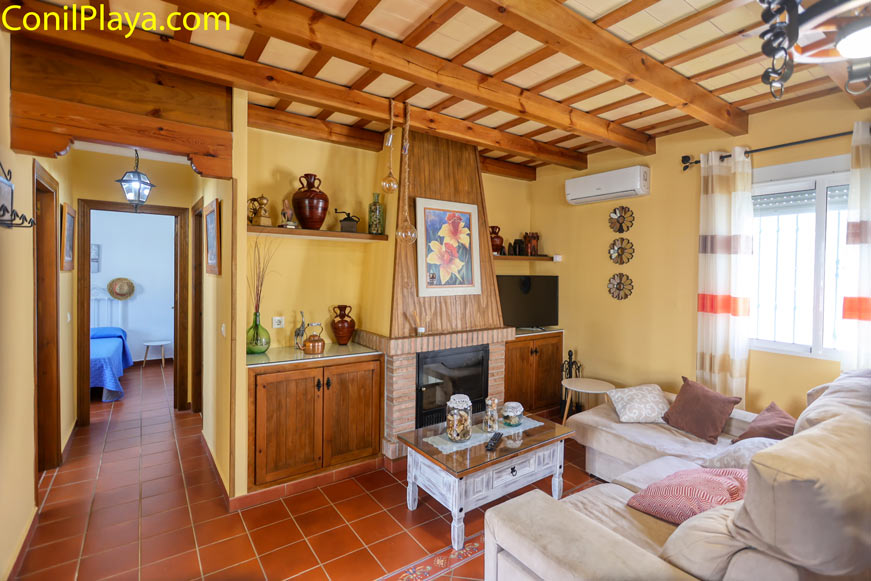 Salón acogedor con sofá chaiselongue y aire acondicionado y chimenea de ladrillo