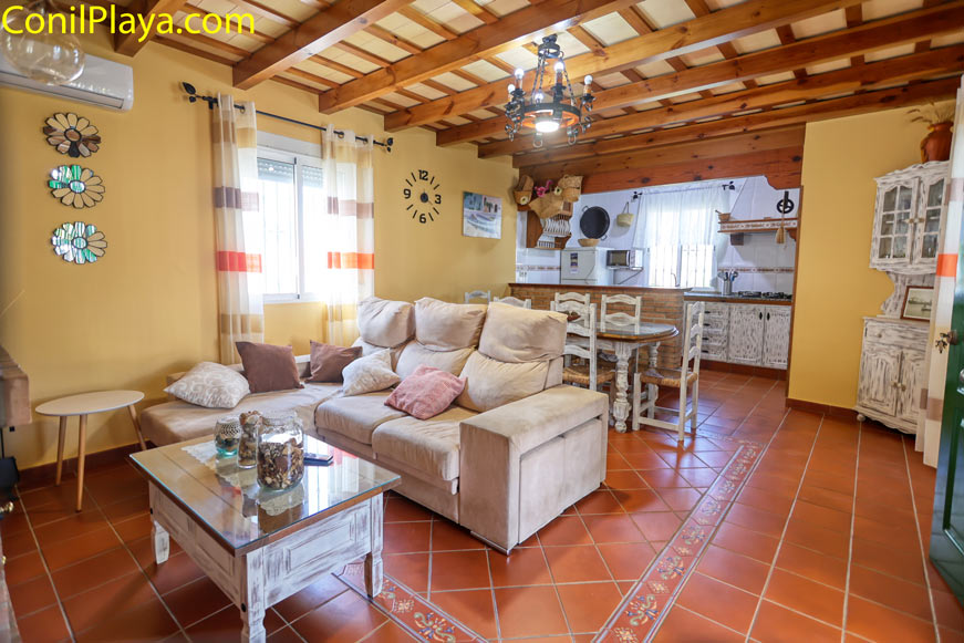 Salón amplio con sofá junto a comedor y cocina