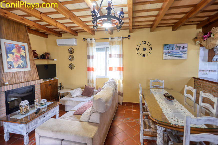Salón comedor con sofá, chimenea, mesa de comedor y decoración rústica