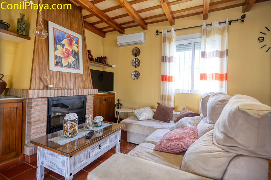 Salón acogedor con sofá amplio, chimenea y mesa decorada con tarros