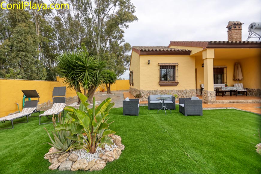 Chalet en Conil con jardín, césped, tumbonas, porche amueblado y barbacoa ideal para alquiler.