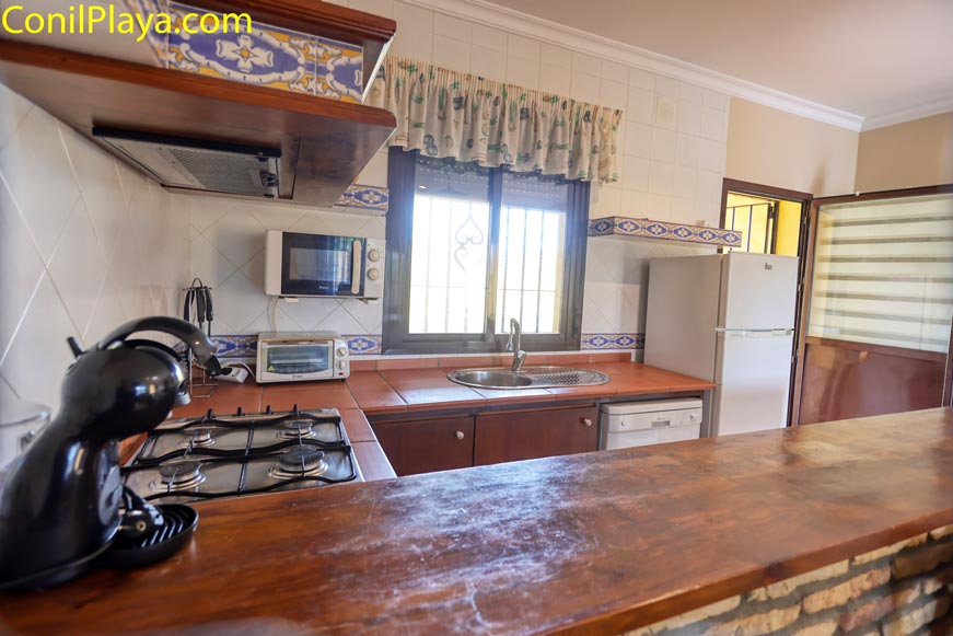 Cocina equipada con nevera, microondas, cafetera y ventana grande exterior