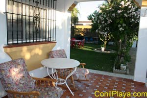 Porche acogedor con mesa y sillas vistas al jardín en chalet en Conil