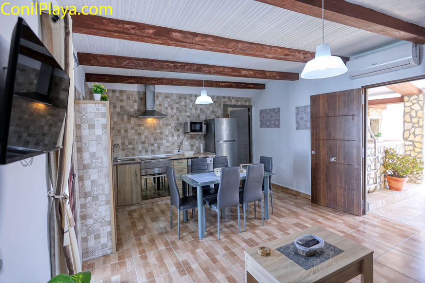 Comedor interior con mesa y sillas junto a cocina equipada moderna