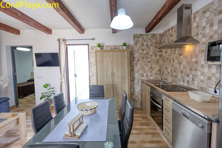 Cocina y comedor modernos con mesa grande y sillas, vista desde la entrada