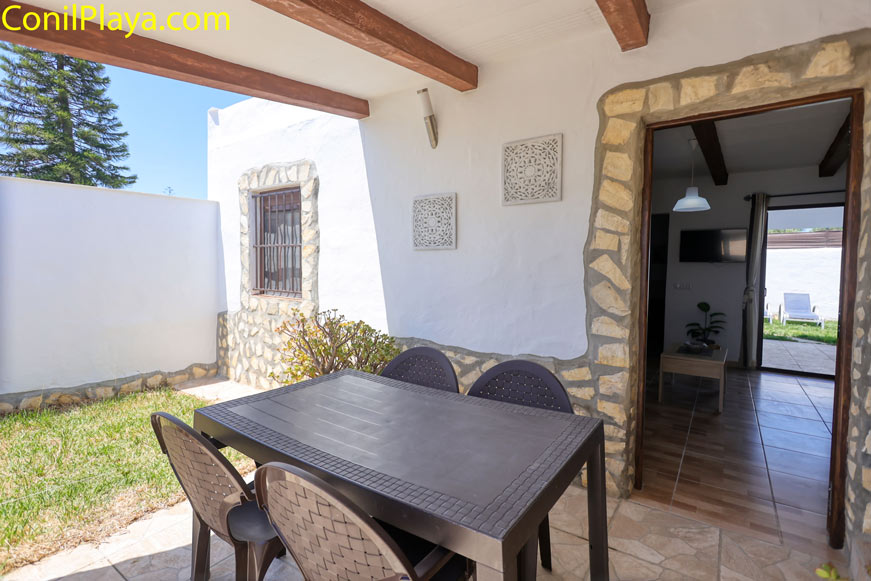 Mesa exterior en el porche de entrada de una casa con paredes blancas