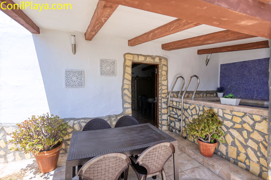 Porche con mesa, sillas y jacuzzi anexo en casa vacacional