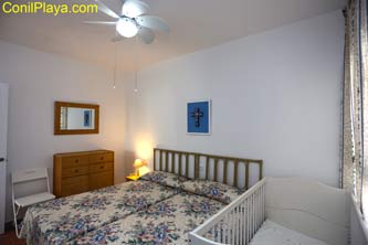 dormitorio con 2 camas y cuna