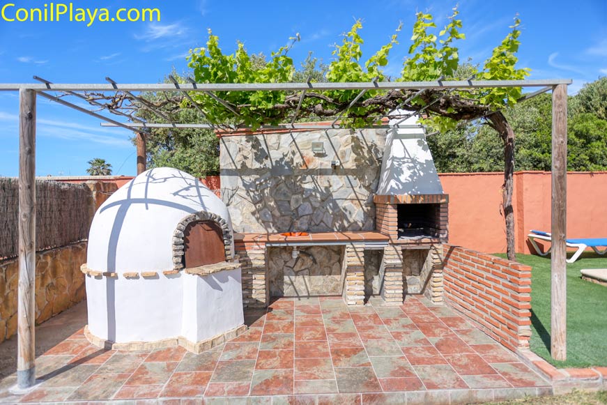 Zona de barbacoa y horno tradicional en el jardín y bajo una parra