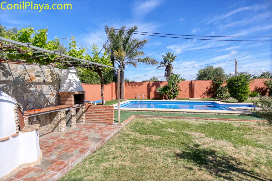 Zona de barbacoa junto a la piscina privada y jardín