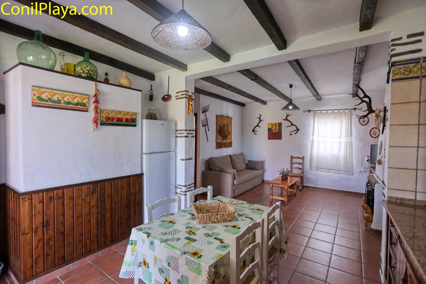 Cocina rústica con mesa comedor y vista parcial hacia el salón