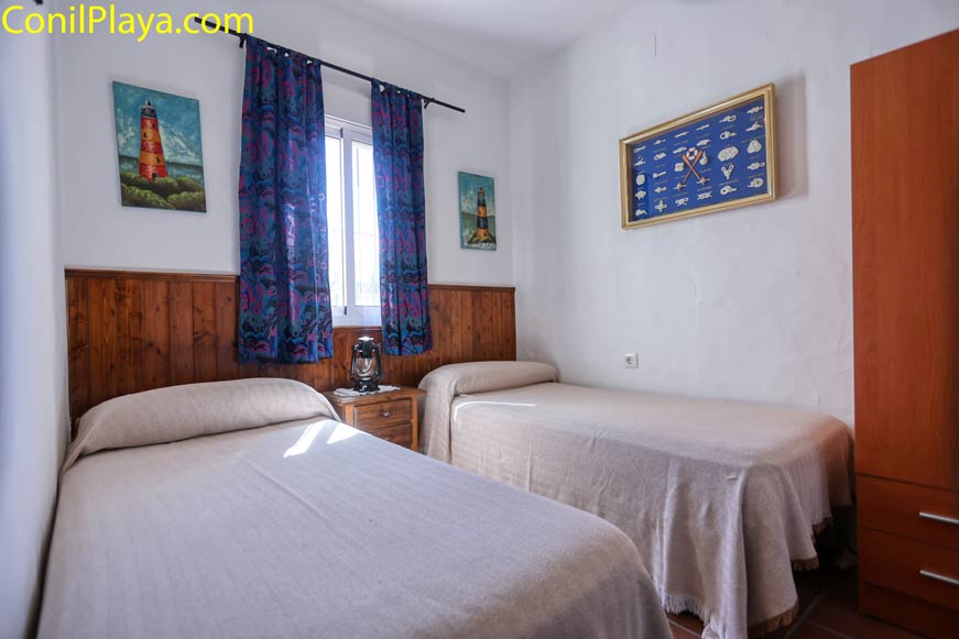 Dormitorio con dos camas individuales y decoración marinera