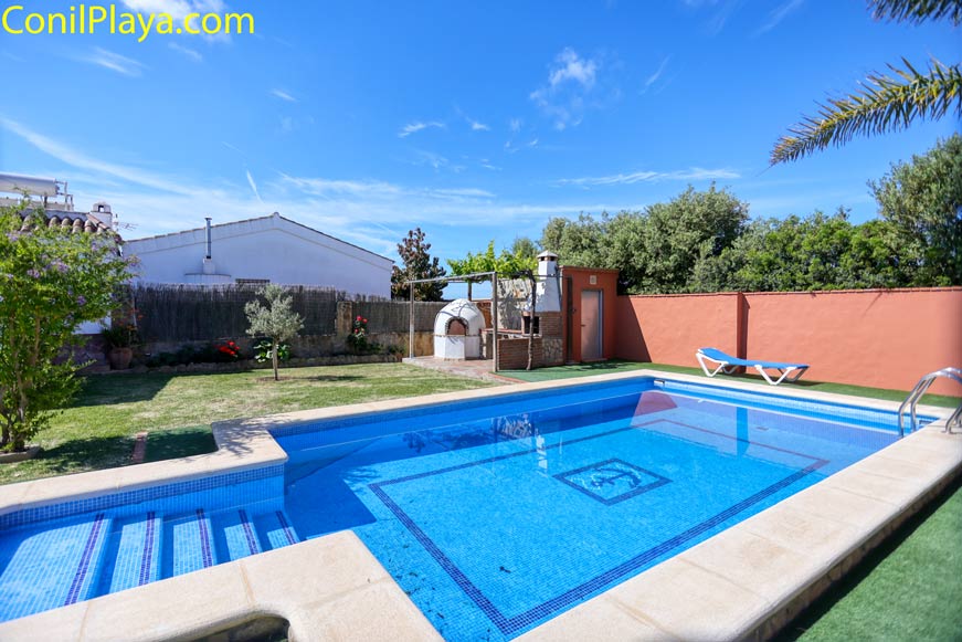 Piscina privada junto a jardín y barbacoa en alojamiento vacacional
