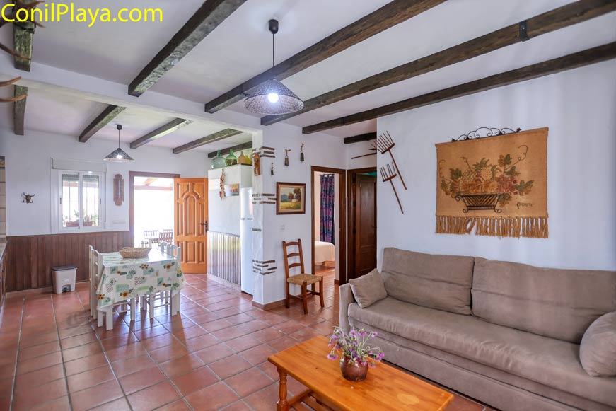 Salón rústico con sofá beige y mesa baja en ambiente acogedor
