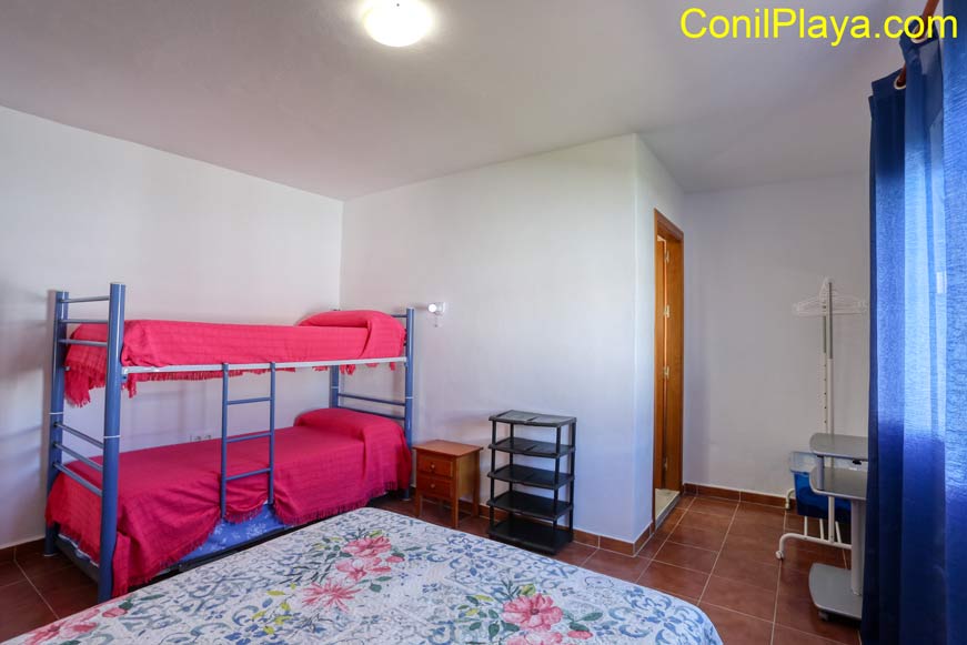 dormitorio con 3 camas individuales y literas