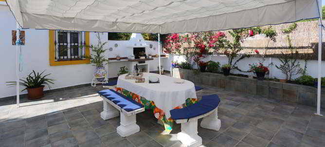 patio con barbacoa, mesa y asientos