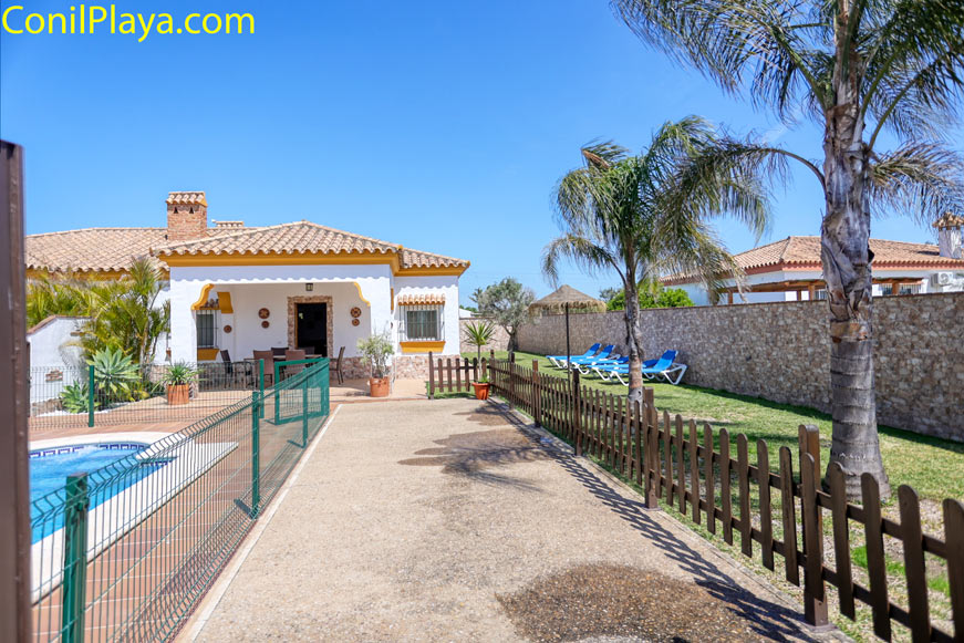 Aparcamiento y entrada chalet Entrada de aparcamiento privado junto a chalet con jardín y piscina vallada