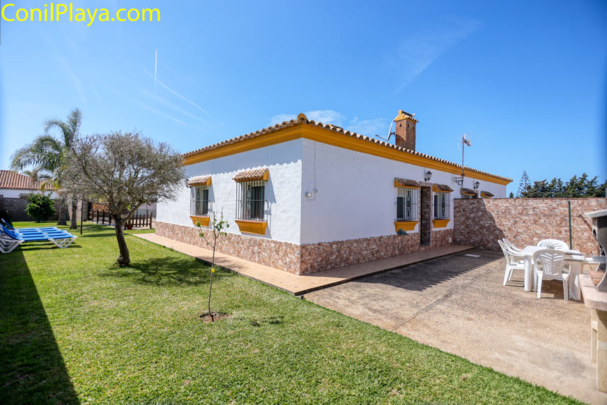 Jardín casa terraza Jardín con césped y árboles, con terraza y tumbonas