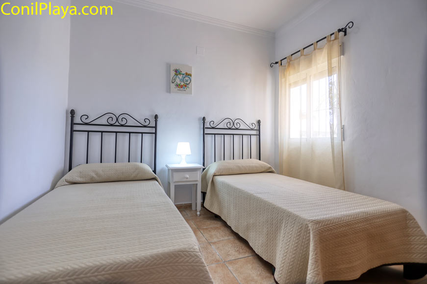 Dormitorio dos camas Dormitorio con dos camas individuales, ventana y luz natural, decoración sencilla