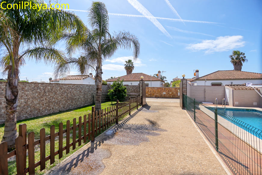Entrada aparcamiento piscina Entrada de aparcamiento junto a piscina privada y jardín con palmeras
