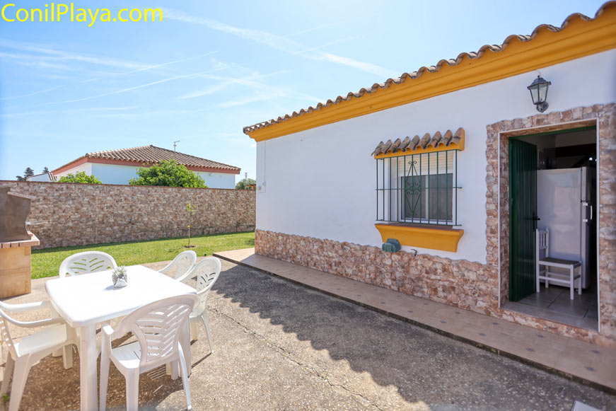 Jardín mesa y barbacoa Jardín con mesa blanca y sillas junto a barbacoa en vivienda soleada