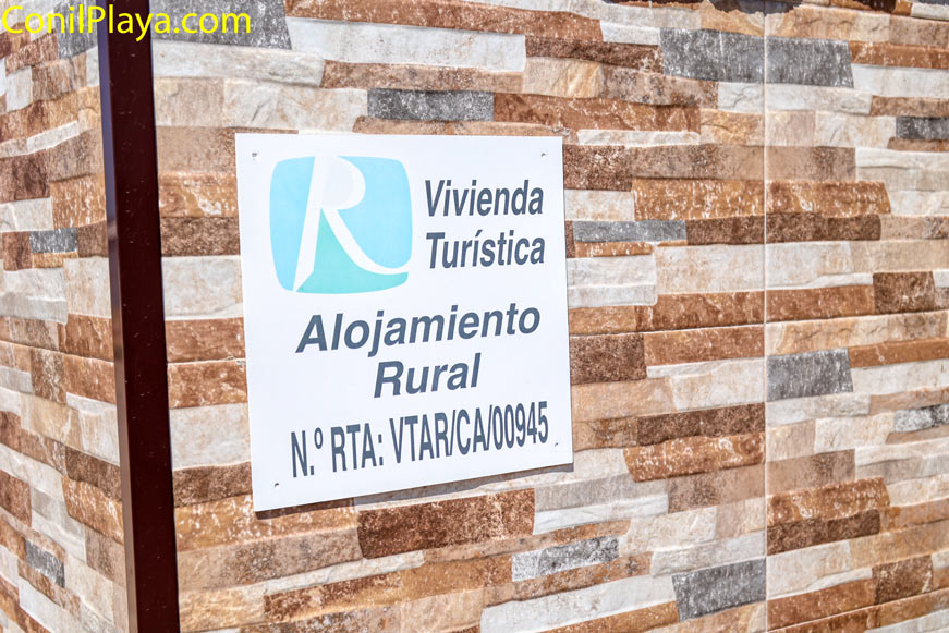 Cartel de alojamiento rural vivienda turística sobre pared de piedra
