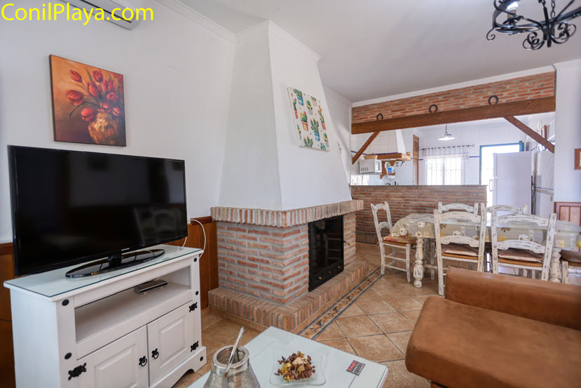 Salón comedor con chimenea Salón comedor con chimenea, televisión y mesa junto a la cocina