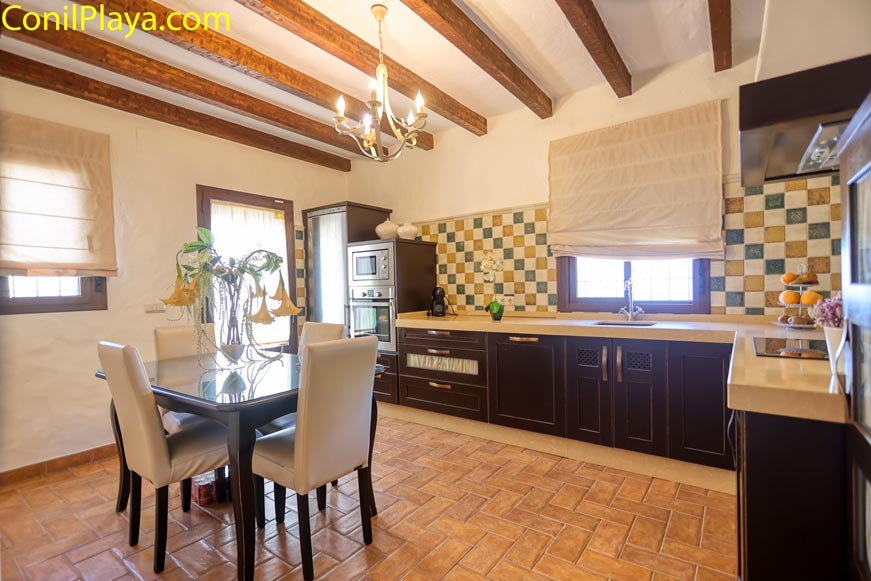 Cocina espaciosa con mesa de comedor y muebles modernos en madera oscura