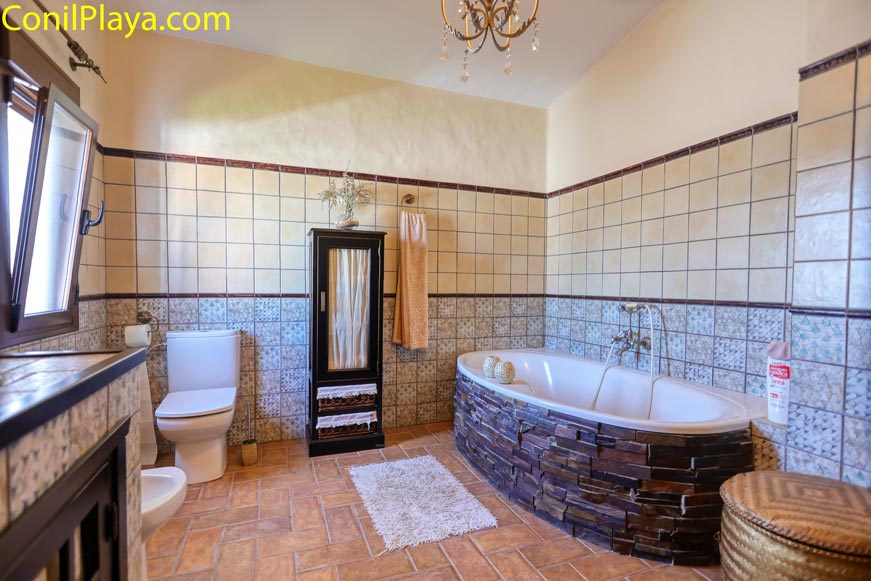 Cuarto de baño amplio con bañera de hidromasaje y decoración rústica