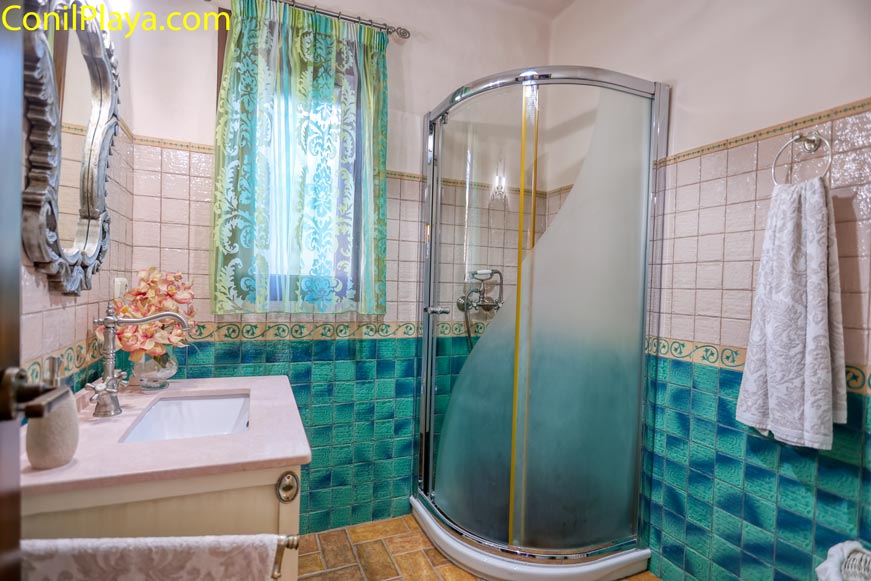 Cuarto de baño con ducha mampara visto desde la entrada al ambiente
